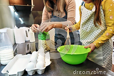 Little girl whipping flour in bowl using culinary whisk Stock Photo