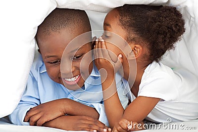 Little girl whispering something to her brother Stock Photo