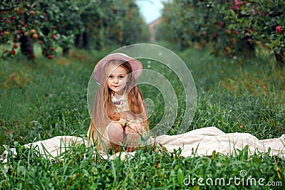 Girl harvest garden trees red pink hat basket picking apples green grass background Stock Photo