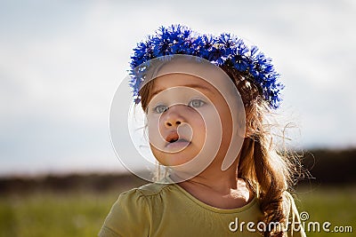 Little girl in a wreath of cornflowers Stock Photo