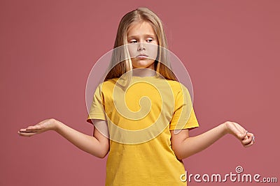 Little girl in a yellow t-shirt. does not know the answer Stock Photo