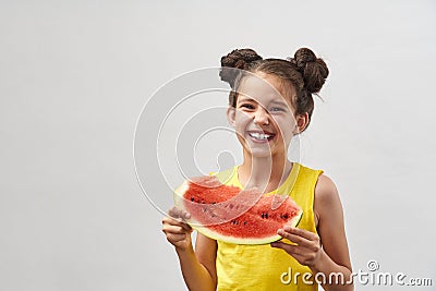 Little girl in yellow t-shirt, laughing merrily and holding slice of watermelon Stock Photo