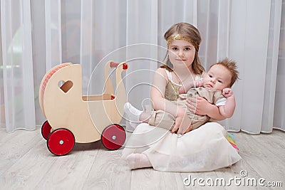 Little girld holds her younger brother Stock Photo