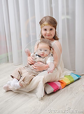 Little girld holds her younger brother Stock Photo