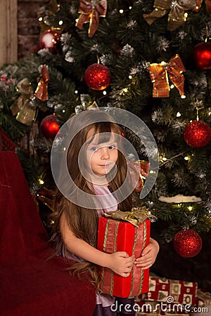 Little girle with christmass gift in her hands Stock Photo