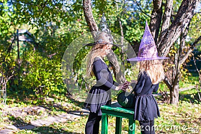 Little girls casting a spell on Halloween in witch Stock Photo