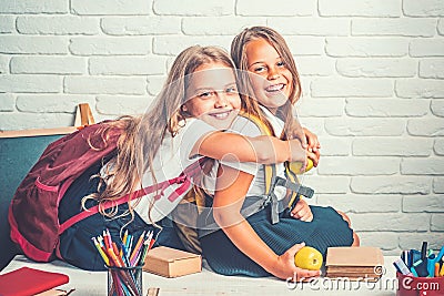 Little girls eat apple at lunch break. little girls eambrace at school lesson. Stock Photo