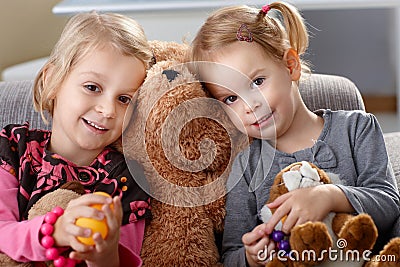 Little girls huddling up against teddy bear Stock Photo