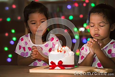 Little girls make folded hand to wish the good things for their birthday Stock Photo