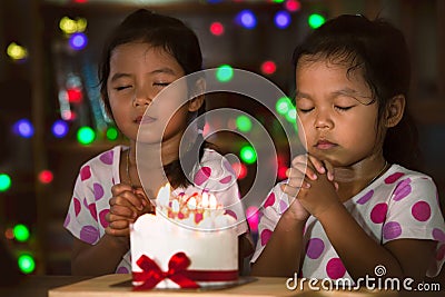 Little girls make folded hand to wish the good things for their birthday Stock Photo