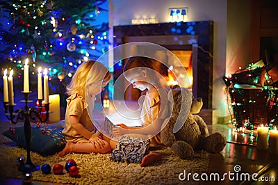 Little girls opening a magical Christmas gift Stock Photo