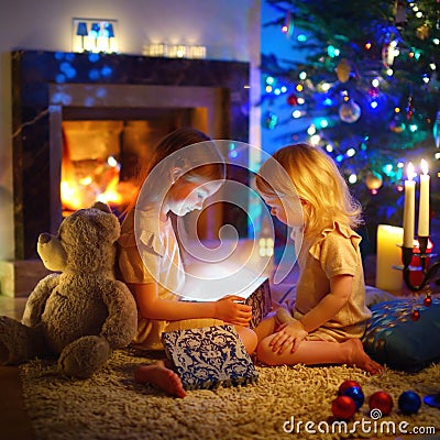 Little girls opening a magical Christmas gift Stock Photo
