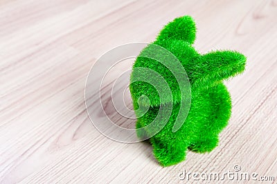 Little green rabbit on wooden floor, made from artificial grass Stock Photo