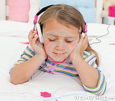 Little gril listening to music with headphones Stock Photo