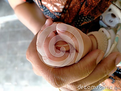 Family concept protection and happiness, the baby`s hand is held by the mother Stock Photo