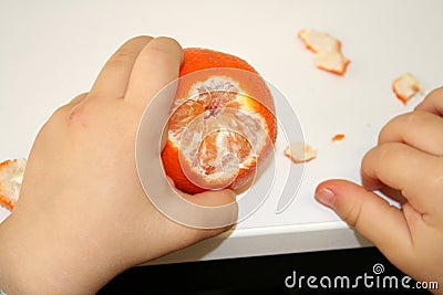 Little hands clean mandarin to have a snack Stock Photo