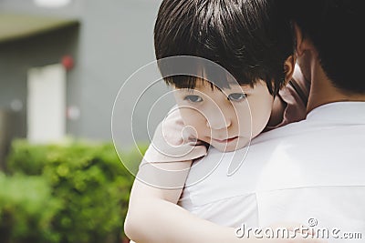 Little handsome Child hug Father during dad carry him and taking son go home after school Young boy get infect virus of flu, sick Stock Photo