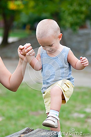 Little happy boy climbing wooden pillar on outdoor playground Stock Photo