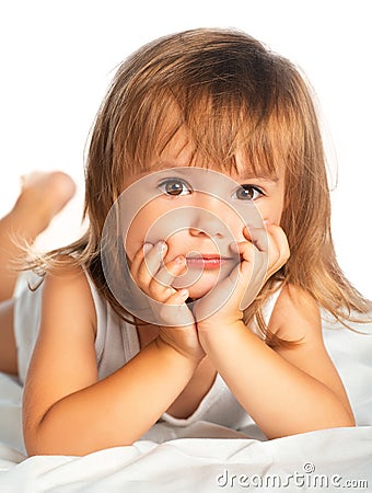 Little happy smiling cheerful girl in a bed isolated Stock Photo