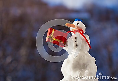 Little happy snowman with christmas gift box outdoor. Winter season. Stock Photo