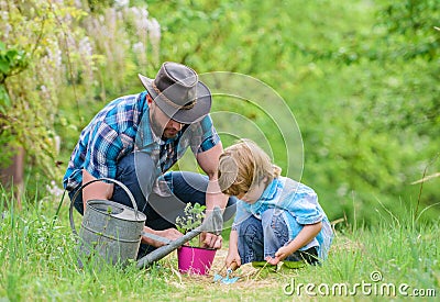 Little helper in garden. Make planet greener. Growing plants. Take care of plants. Day of earth. Boy and father in Stock Photo