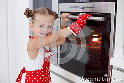 Little housewife engaged in baking muffins in the kitchen at home Stock Photo