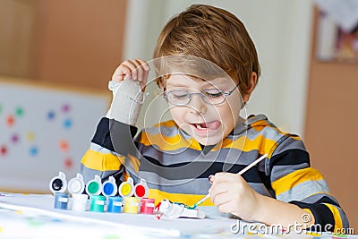 Little kid boy drawing with colorful watercolors indoors Stock Photo