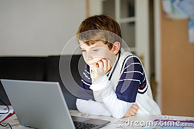 Little kid boy making school homework on computer notebook. Happy healthy child searching information on internet. New Stock Photo