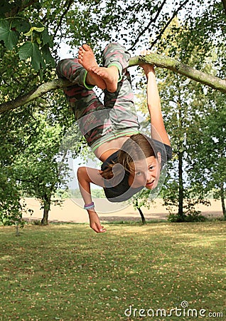 Little kid - girl hanging on branch Stock Photo