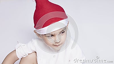A little kid making a funny annoyed face. Annoyed Christmas Boy in Santa Hat. A really serious and handsome kid Stock Photo