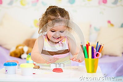 Little kid playing with colorful clay Stock Photo