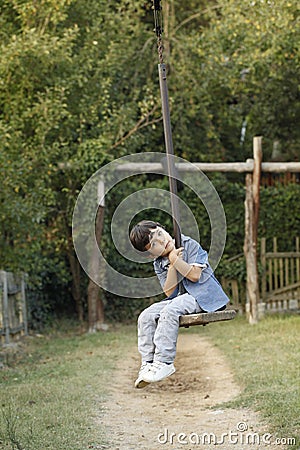 Little kid sitting on toy cable car in a children's playground Stock Photo