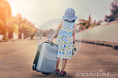 A little kid with a suitcase escape from house Stock Photo