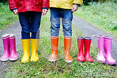 Little kids, boys and girls in colorful rain boots. Children standing in autumn forest. Close-up of schoolkids and Stock Photo