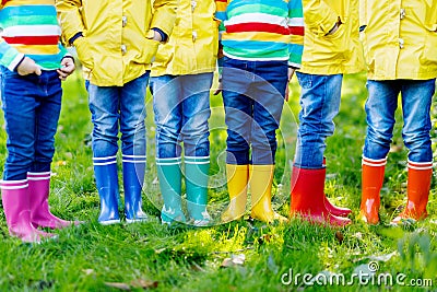 Little kids, boys and girls in colorful rain boots. Close-up of children in different rubber boots, jeans and jackets Stock Photo