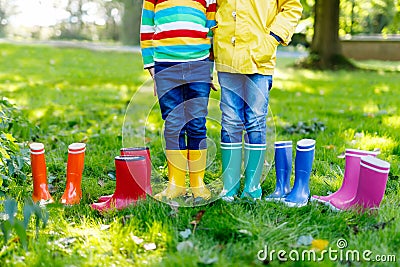 Little kids, boys or girls in jeans and yellow jacket in colorful rain boots Stock Photo