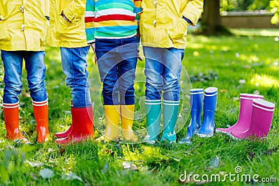 Little kids, boys or girls in jeans and yellow jacket in colorful rain boots Stock Photo