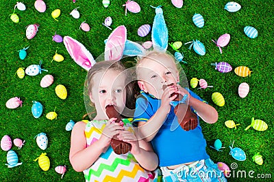 Little kids eating chocolate rabbit on Easter egg hunt Stock Photo