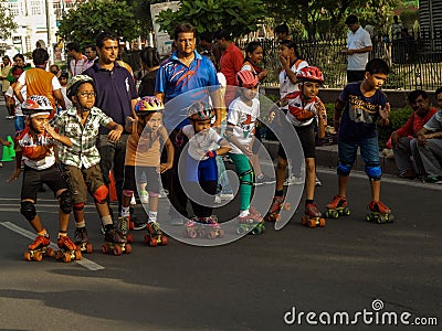 Little kids enjoying skating with their parents. Editorial Stock Photo