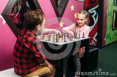 Little kids playing chess in entertainment center Stock Photo