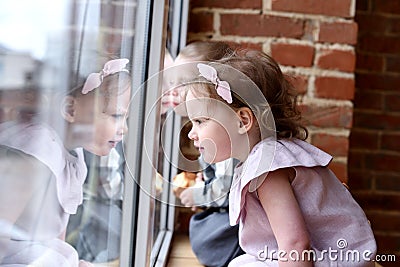 Little kids or siblings concept. Cute toddler girl and boy at window sill looking outside Stock Photo