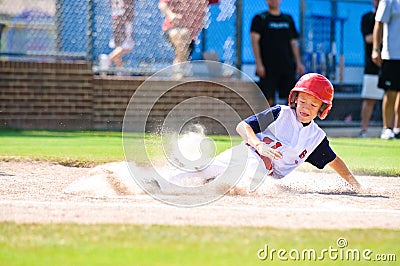 Little league baseball player sliding home. Stock Photo
