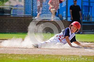Little league baseball player sliding home. Stock Photo