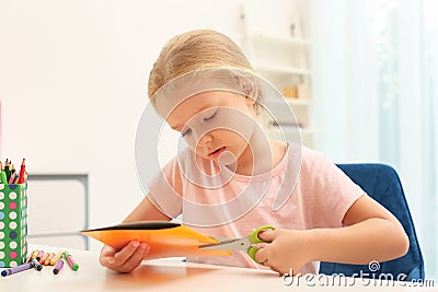 Little left-handed girl cutting construction paper Stock Photo
