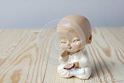 Little monk's praying, Statue neophyte on pine wood background Stock Photo