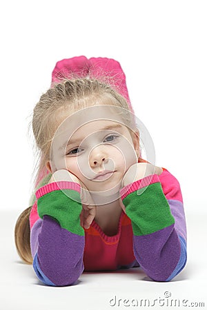 Little pensive girl lying down on the floor Stock Photo