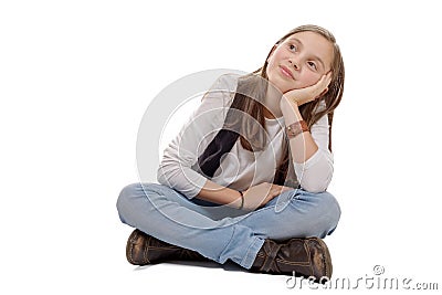 Little pensive girl sitting cross-legged on a white background Stock Photo