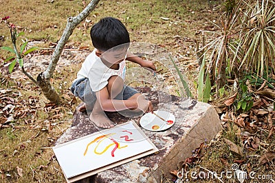 Little playing panit on white paper in the garden Stock Photo