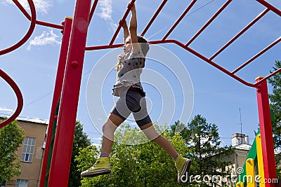 Little preschool girl hanging walk along the monkey bars Stock Photo