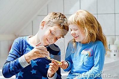 Little preschool girl and preteen school boy brushing teeth. Brother teaching sister brush teeth. Happy siblings. Two Stock Photo